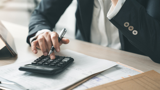 Man sitting at his desk with documents and a calculator